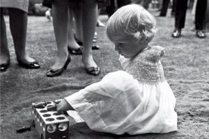young girl with no arms due to thalidomide damage playing with a toy with her feet