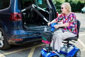 woman in wheelchair by car with hoist fitted