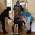 elderly lady coming out of hospital in wheelchair