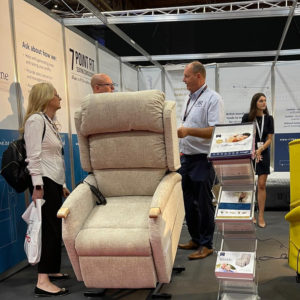 Tilting chair at Naidex show in forward tilt position to help someone stand up out of the chair