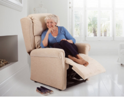 Lady sitting on an adjustable armchair that has the footrest in a raised position for comfort